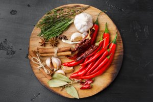 Garlic cloves and spices on black background