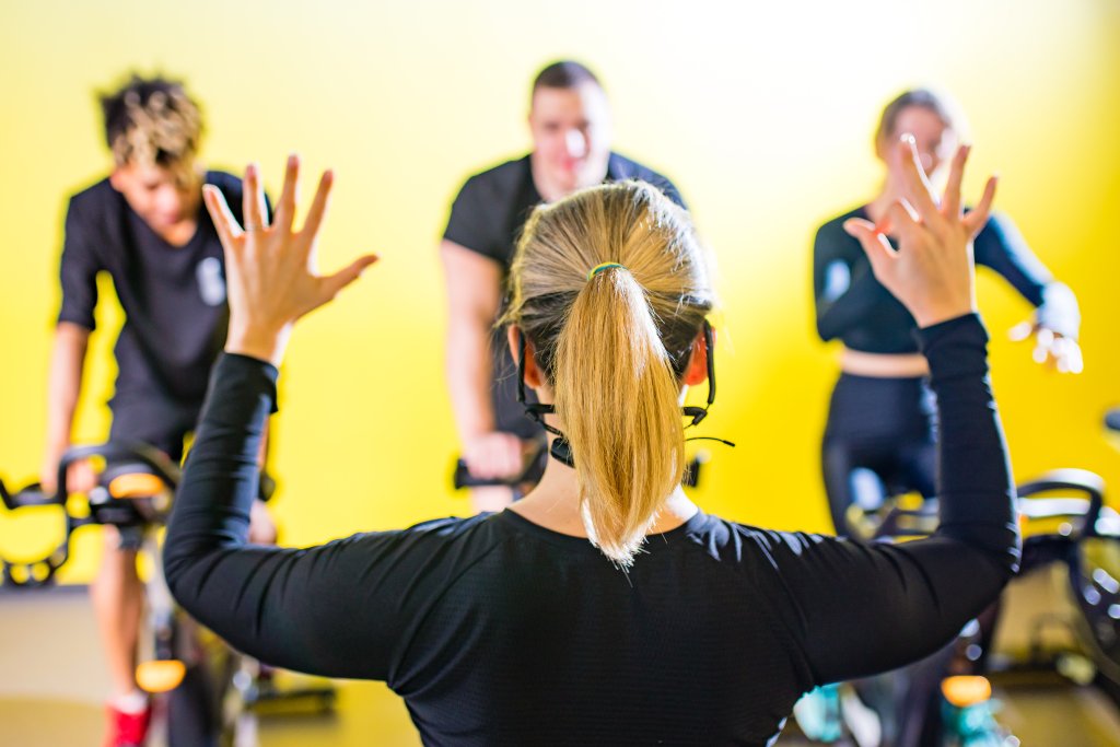 stress management: multicultural group of happy young strong people cycling In class