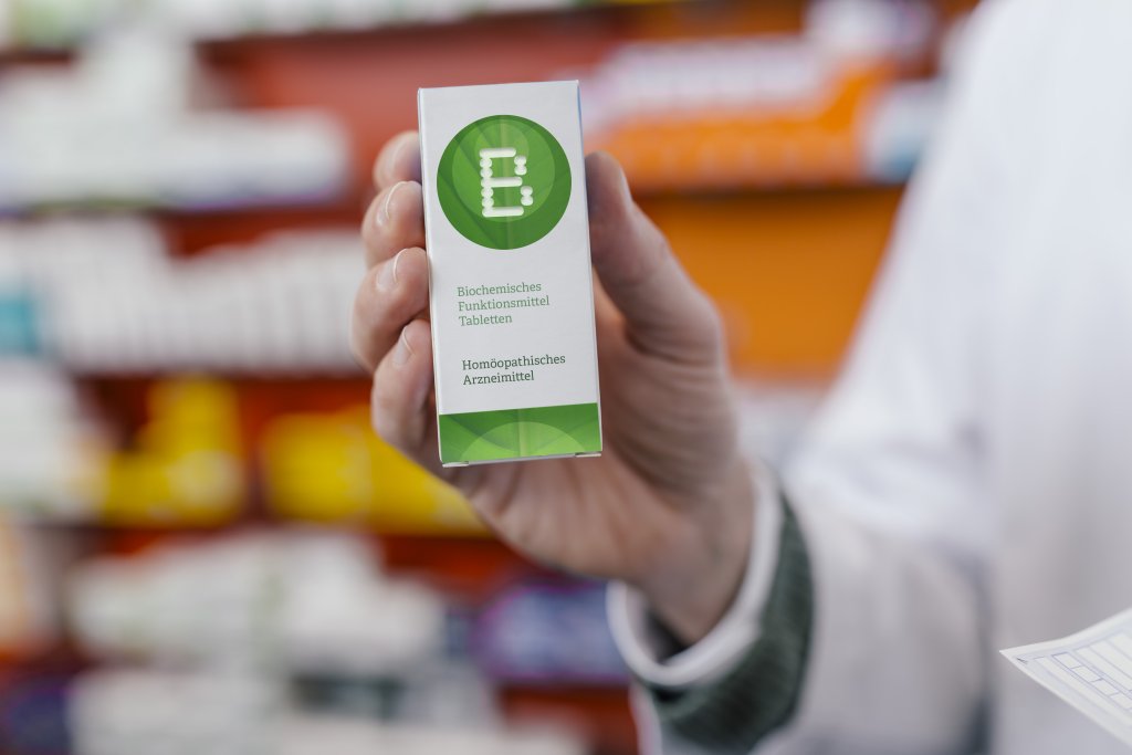 Pharmacist holding homeopathic medicine in pharmacy