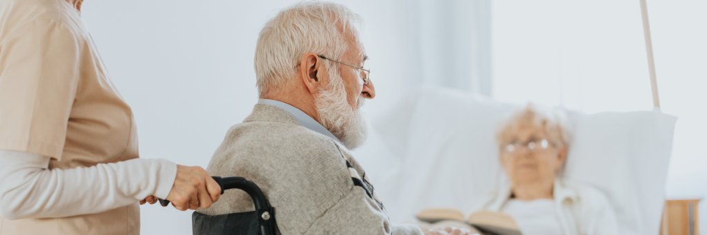 Senior man after stroke sits in a wheelchair at a nursing home