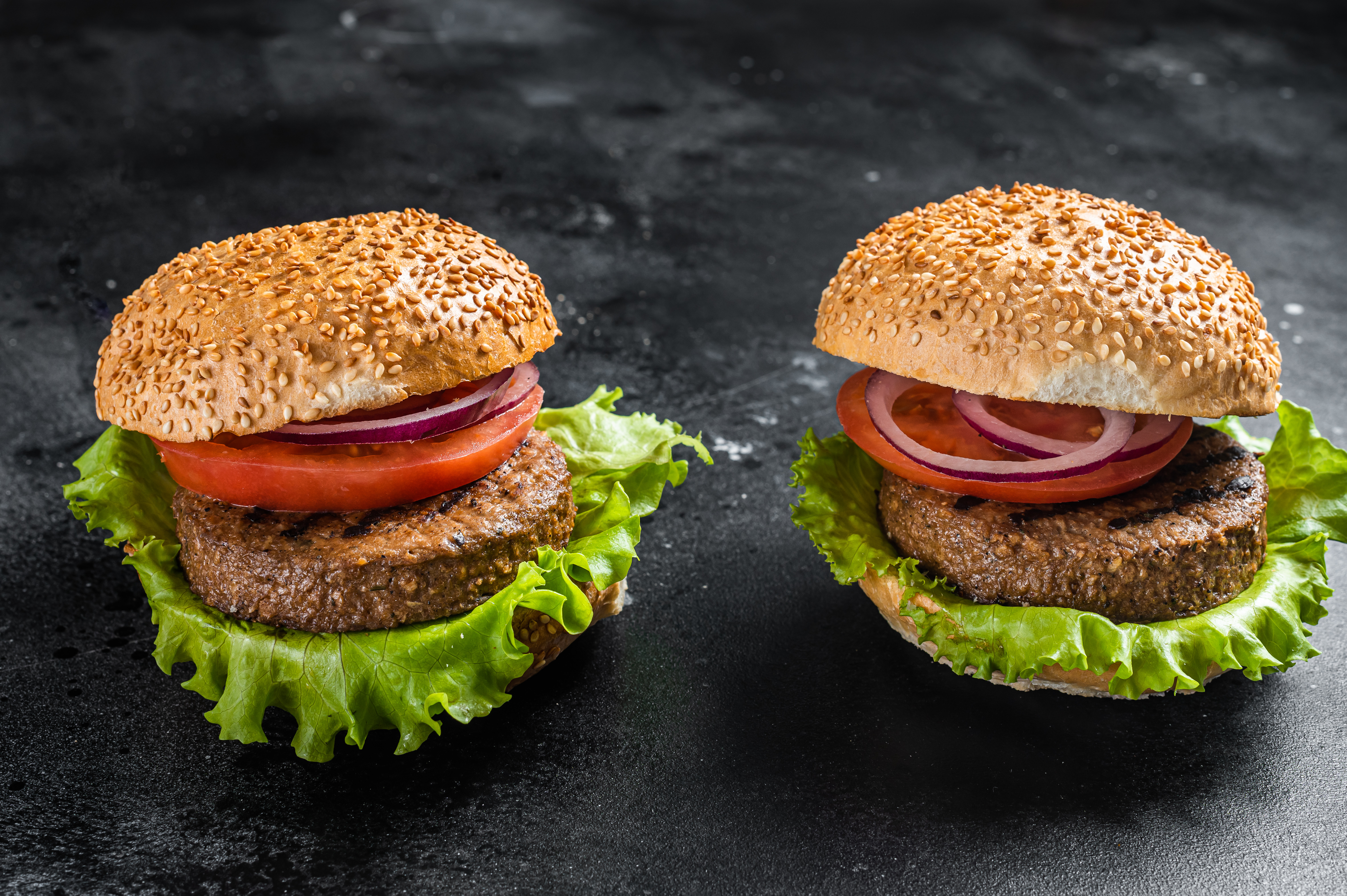 Vegan burger with Plant based meatless cutlets, patties, tomato and onion.