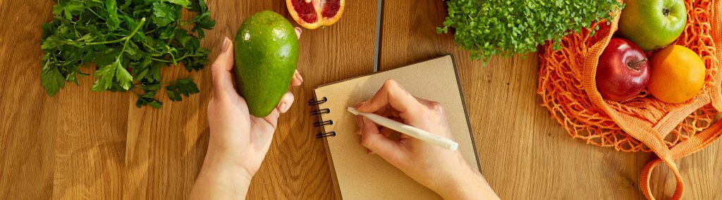 Children: Woman planning, writing weekly meals on a meal planner note or diet plan