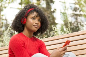 young woman listening to music with headphones with an expression of self-confidence