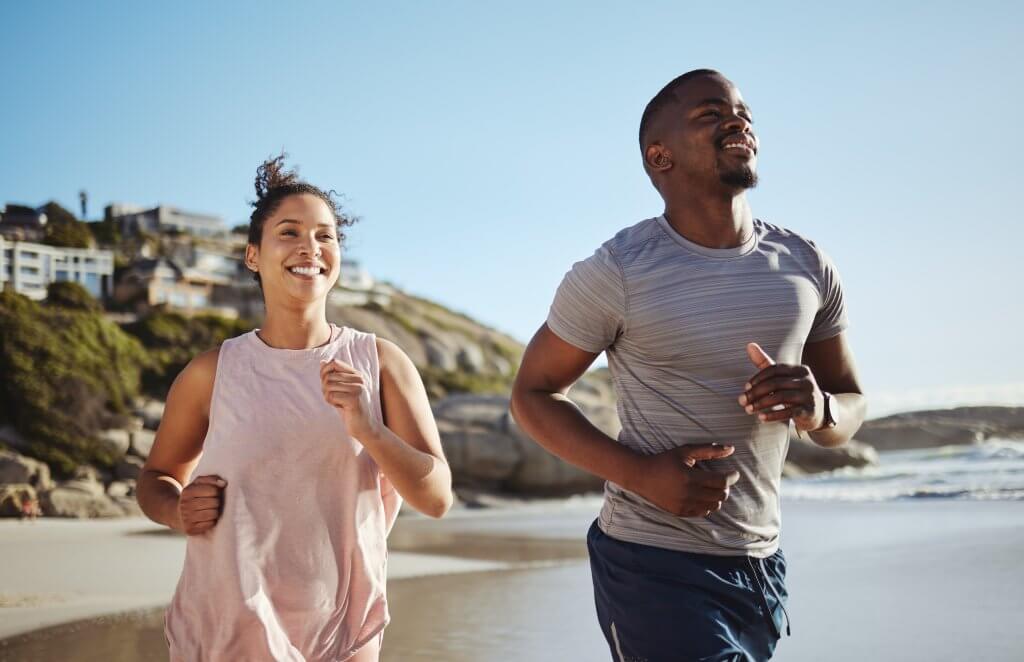 Fitness, beach and running black couple training, workout and exercise for cardiovascular wellness