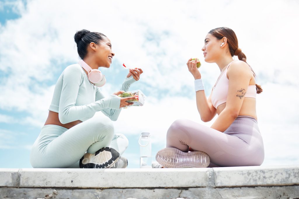 mental Health-Salad, apple and fitness friends eating food outdoor for wellness, diet and vegan lifestyle with bl