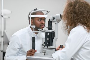 Sideview of patient looking at apparatus during vision checking with oculist