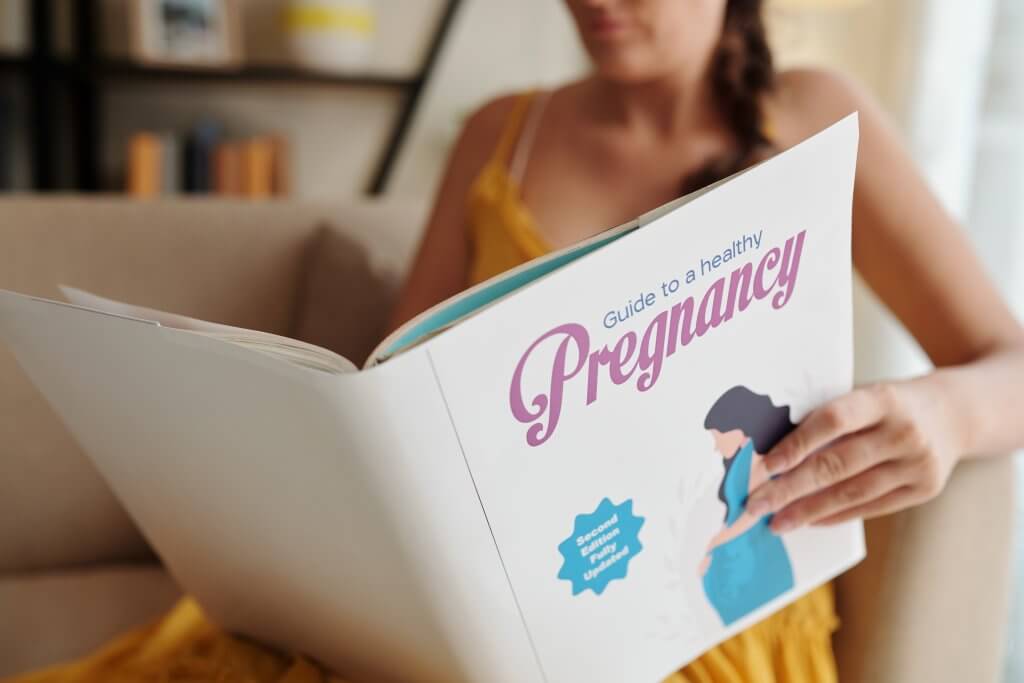 Woman Reading Pregnancy Guide
