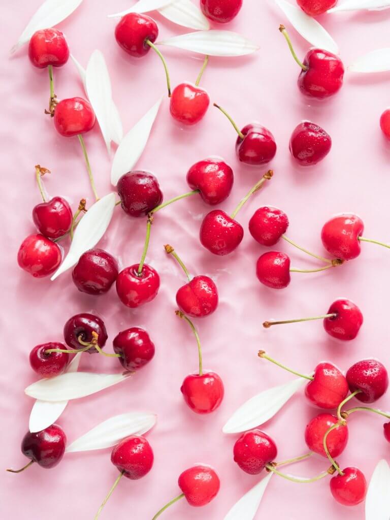 Hydrating Foods-Cherry berry pattern with flowers and petals in water on pink background