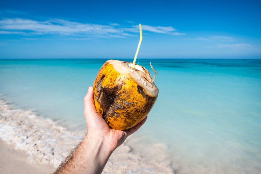 Drinking fresh young coconut on the beach