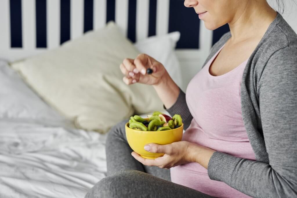 Health Hacks-Pregnant woman eating healthy fruity snack