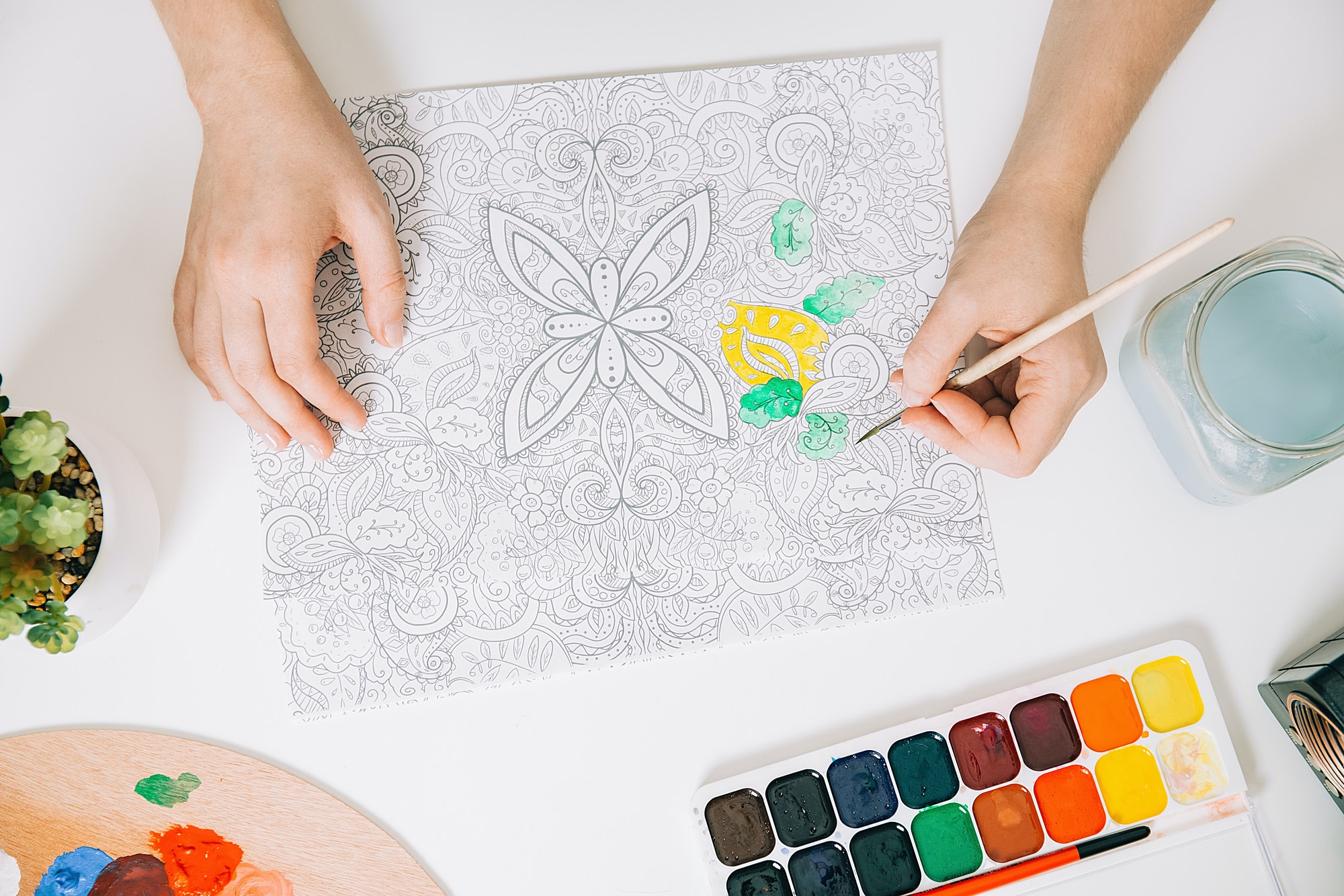 Young woman is coloring page anti stress book, mental wellbeing concept.